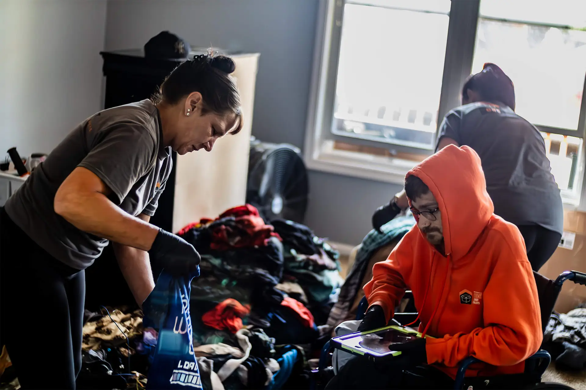 CRS Employee in a room with a man in a wheelchair handling contents for CRS team