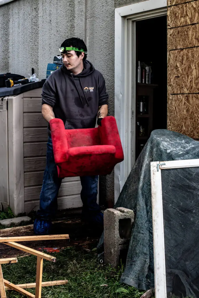 A CRS employee holding a red chair during recovery services