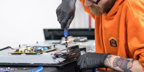 A CRS Employee conducting Electronics Restoration on a TV