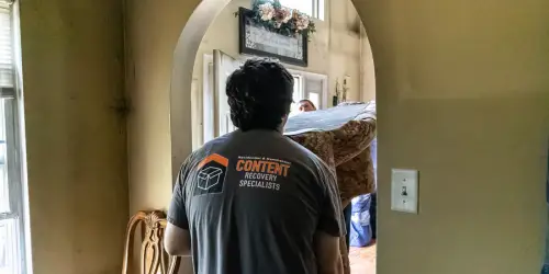 CRS carrying a couch for packout and furniture restoration
