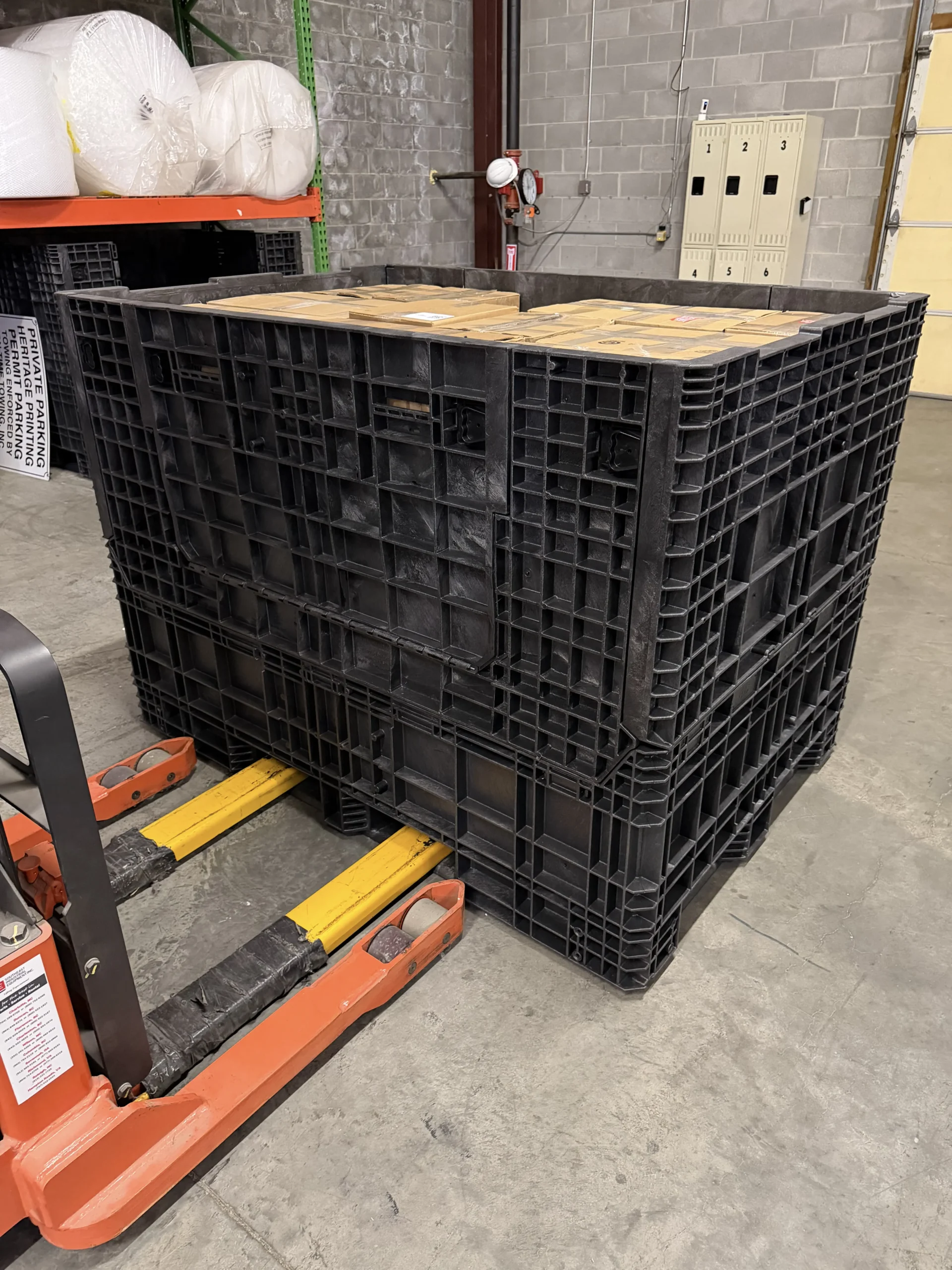 A forklift carrying a Buckhorn storage container